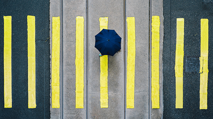Umbrella Stripes Person mit Schirm läuft über Strasse. Abstrakt. Foto.